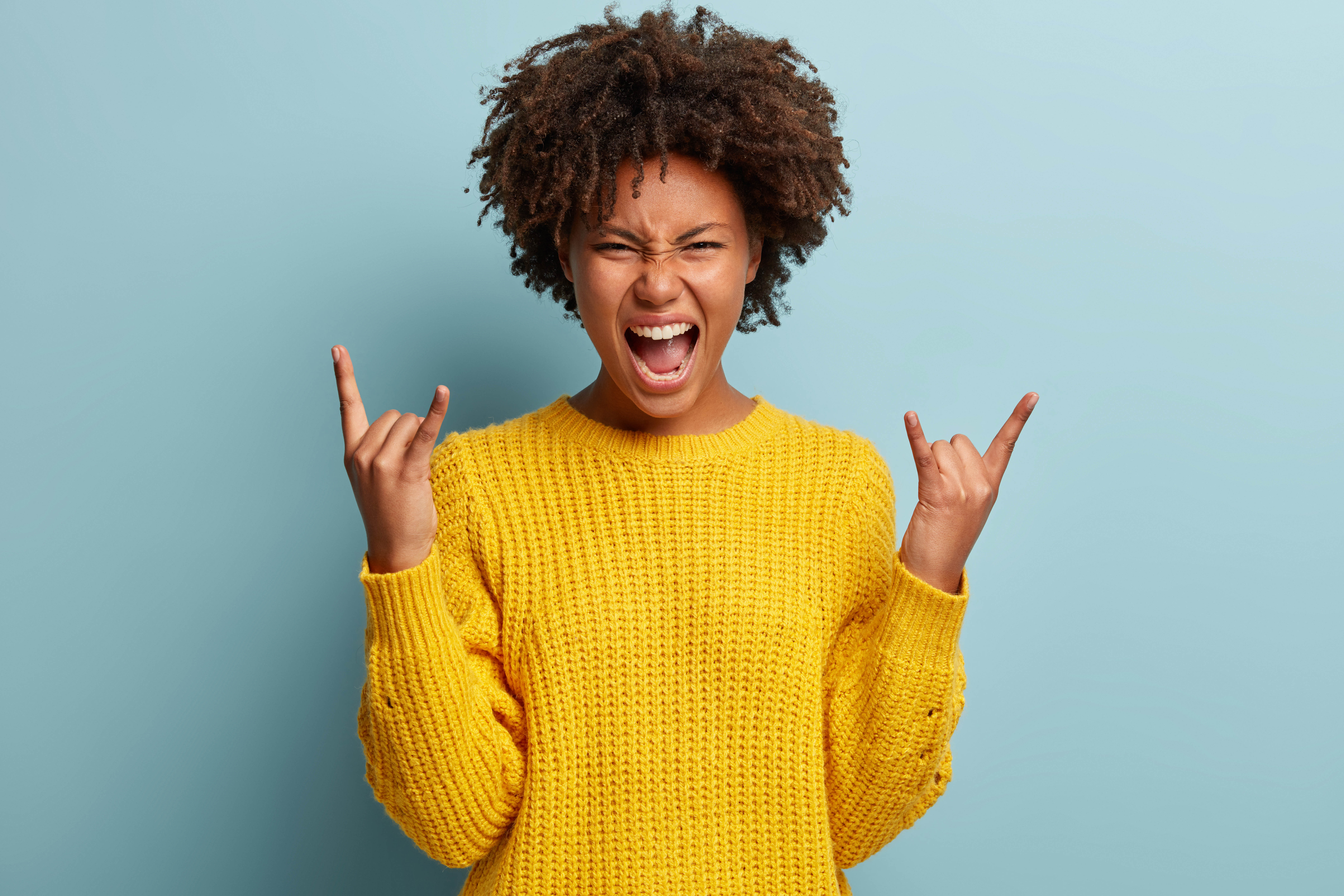 Excited black woman in a bright yellow sweater